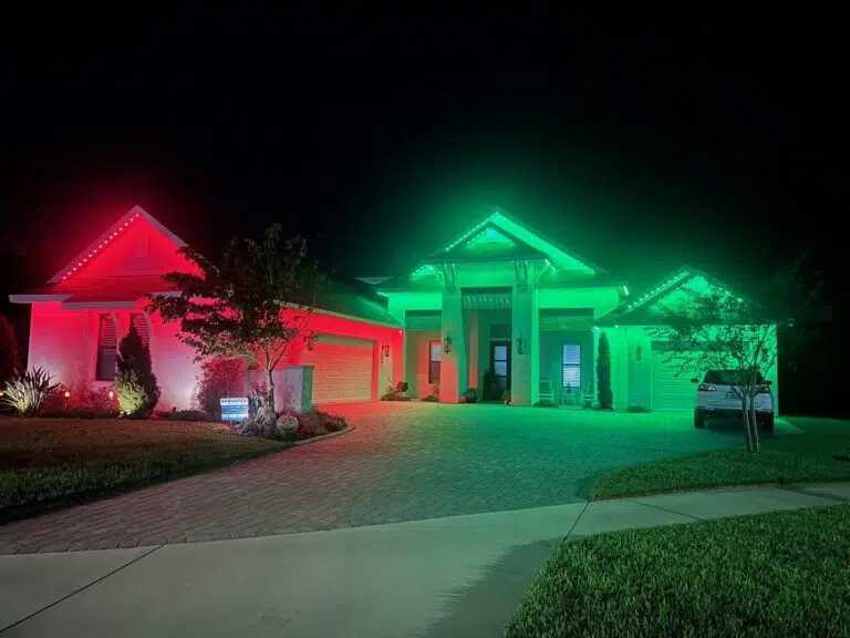 Red and green accent lighting on the front of a Spring Hill home during the evening.