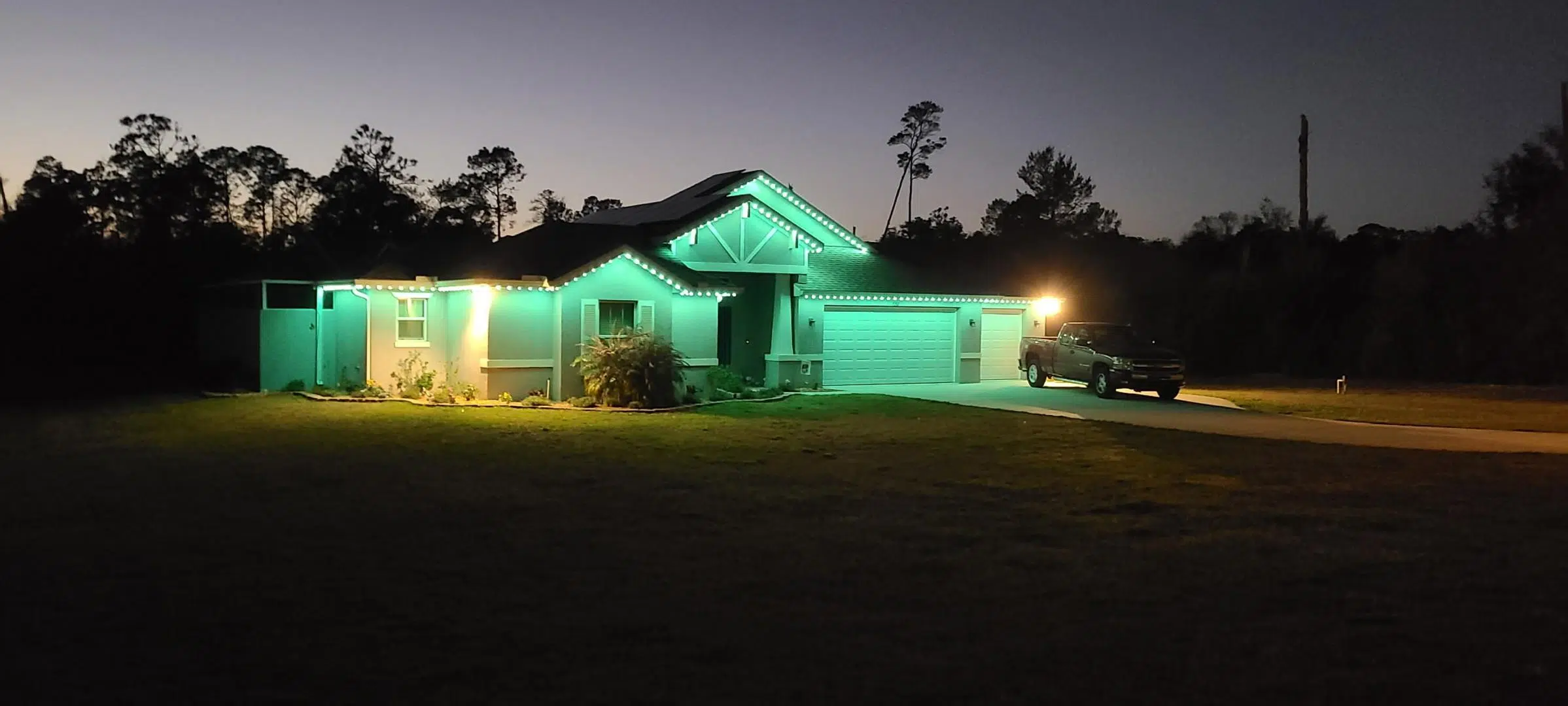 Colorful LED lights illuminating the front of a single-story home in Lutz.
