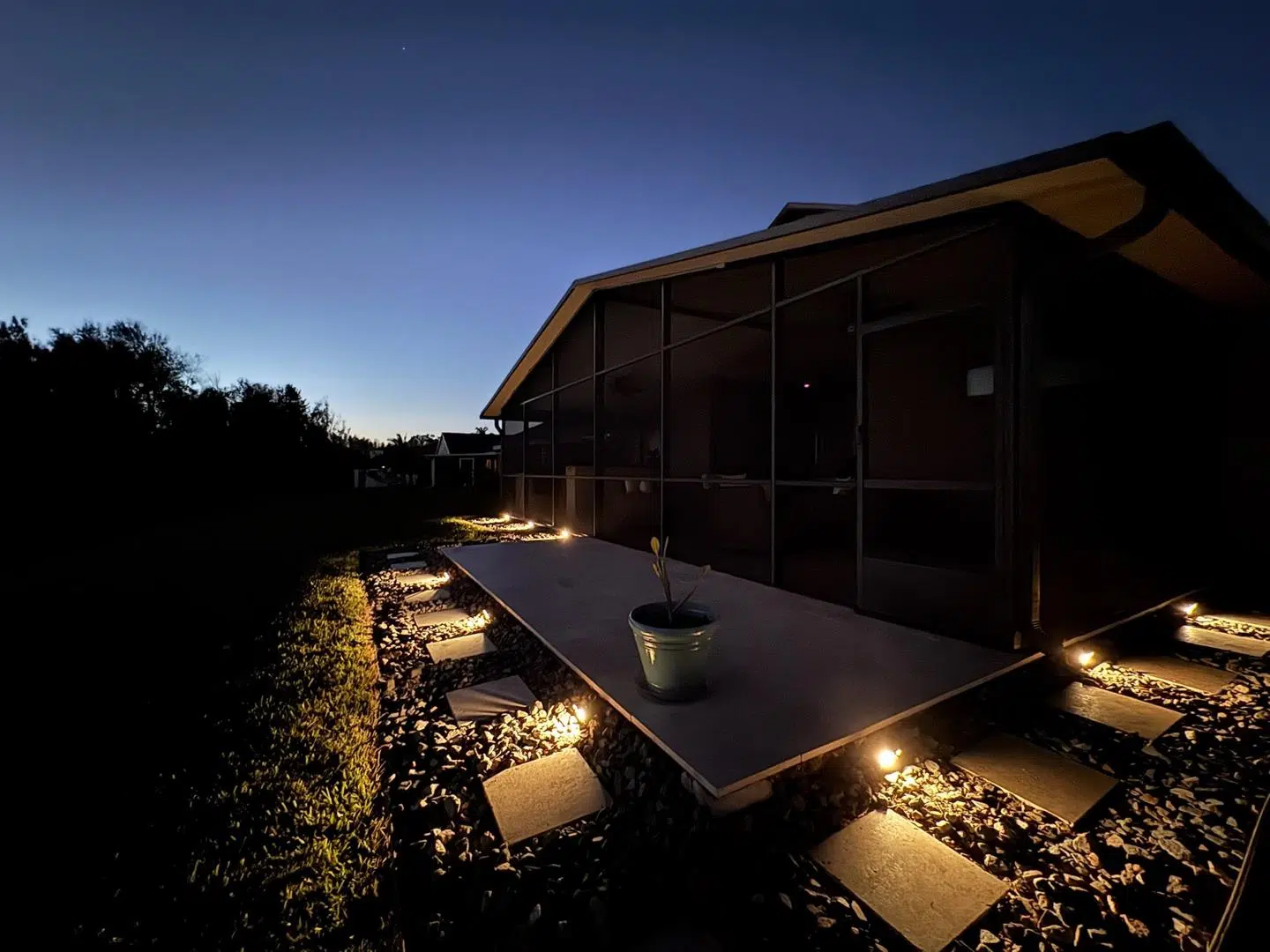 Warm LED lighting on deck stairs and landscaping during twilight at a Spring Hill home.