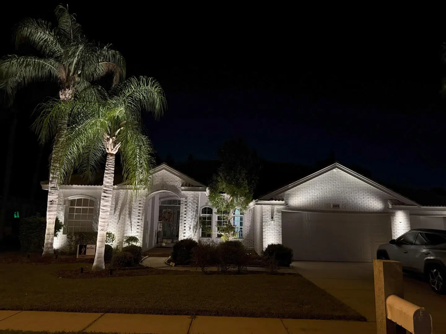 Soft outdoor lighting on the driveway and entry of a Lutz residence.