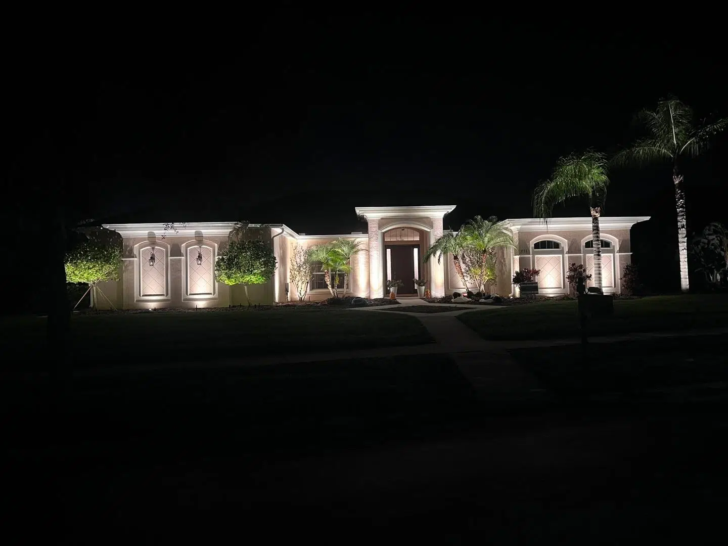 Clean white LED lighting illuminating the columns and entry of a large Odessa home.
