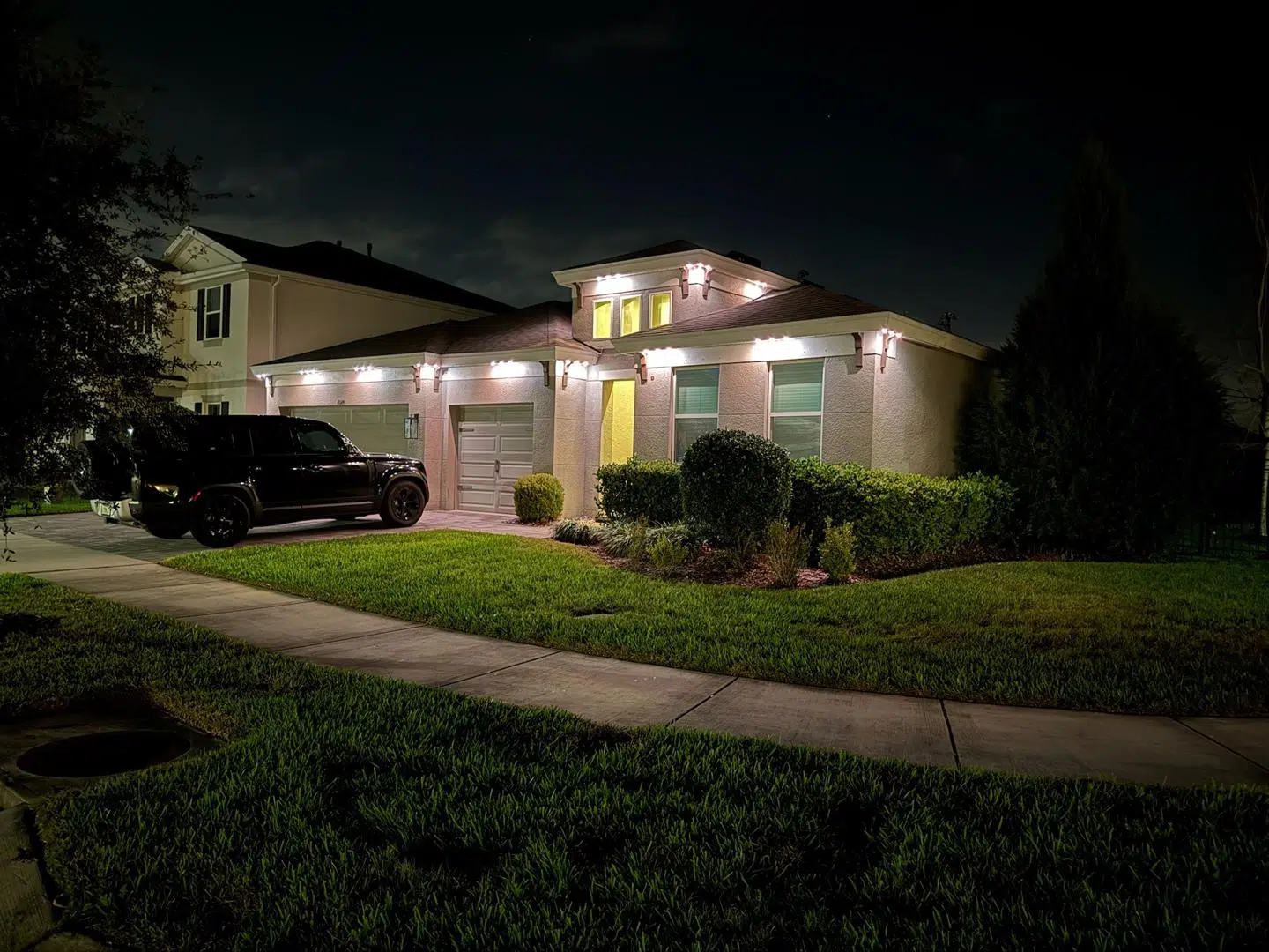 Soft landscape lighting illuminating trees and entryway in a quiet Keystone neighborhood.