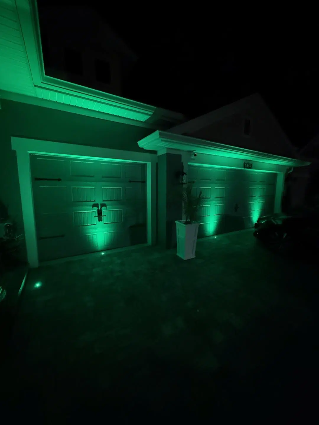 Deep green LED lighting along the garage and columns of a Keystone home.