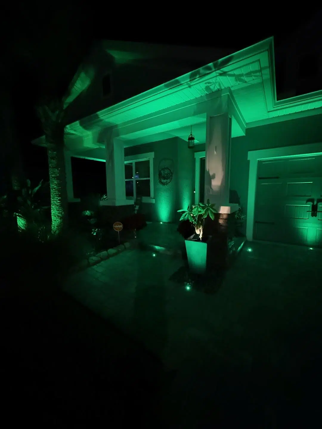 Green accent lighting used on the front porch pillars and landscaping of an Odessa home.