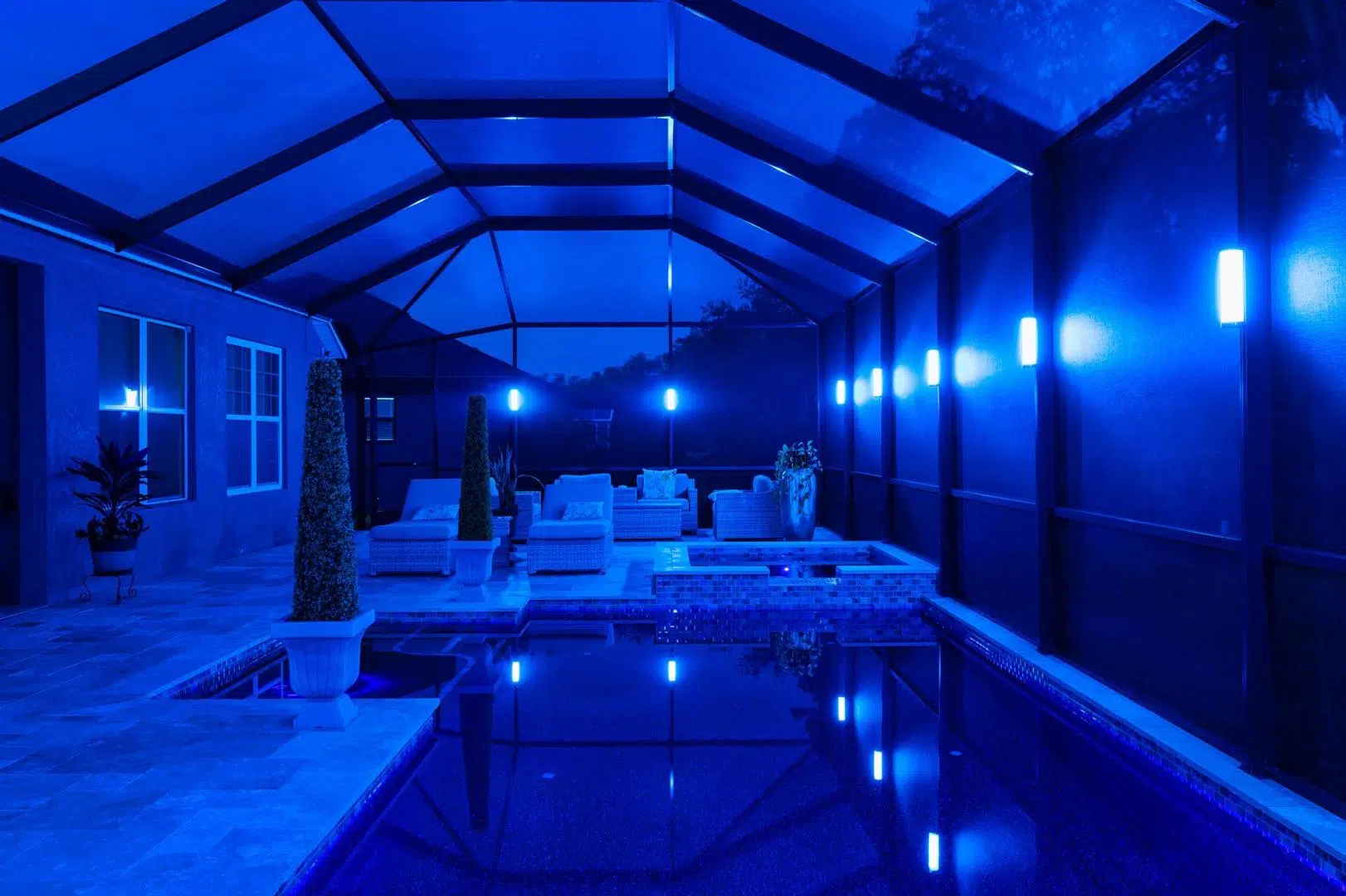 Sleek blue lighting inside a screened pool enclosure at a Wesley Chapel property.