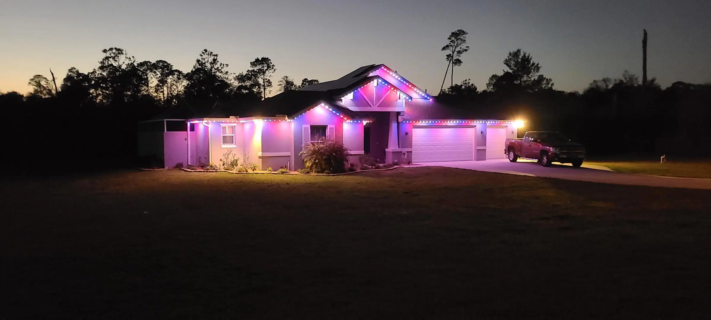 Wide purple LED lighting setup across the front of a single-story home in Palm Harbor.