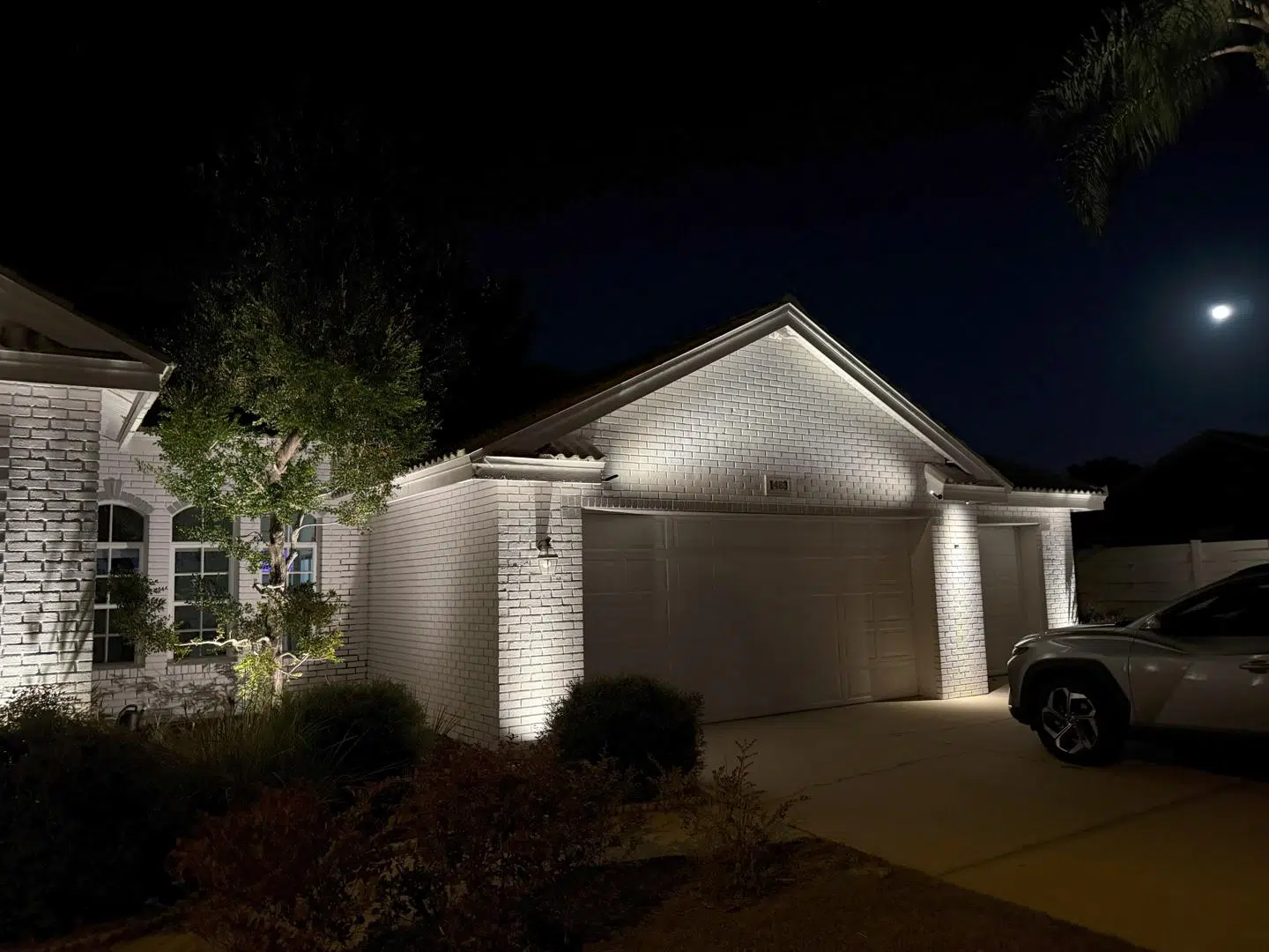 Warm lighting around the garage and entryway of a single-story home in Tarpon Springs.